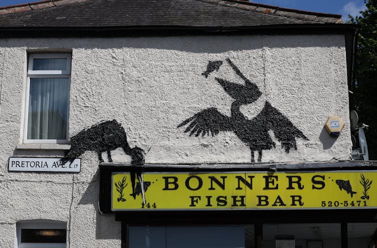 Stenciled pelicans above a fish bar.